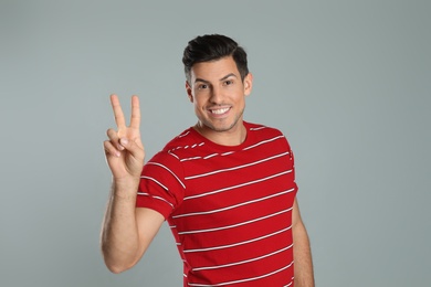 Photo of Man showing number two with his hand on grey background