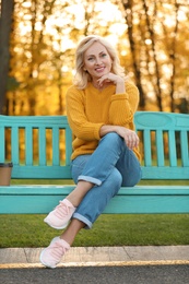 Photo of Portrait of happy mature woman on bench in park