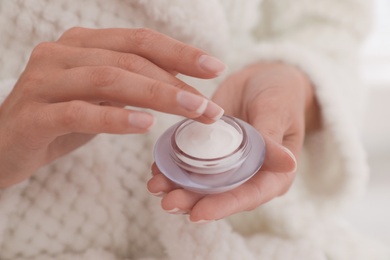 Photo of Woman holding open jar with cream, closeup