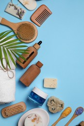 Photo of Flat lay composition with different spa products and tropical leaf on light blue background. Space for text