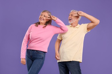 Photo of Senior couple dancing together on purple background