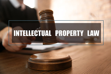 Image of Intellectual property law. Judge with gavel at table, closeup