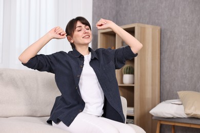 Photo of Beautiful young housewife on sofa at home