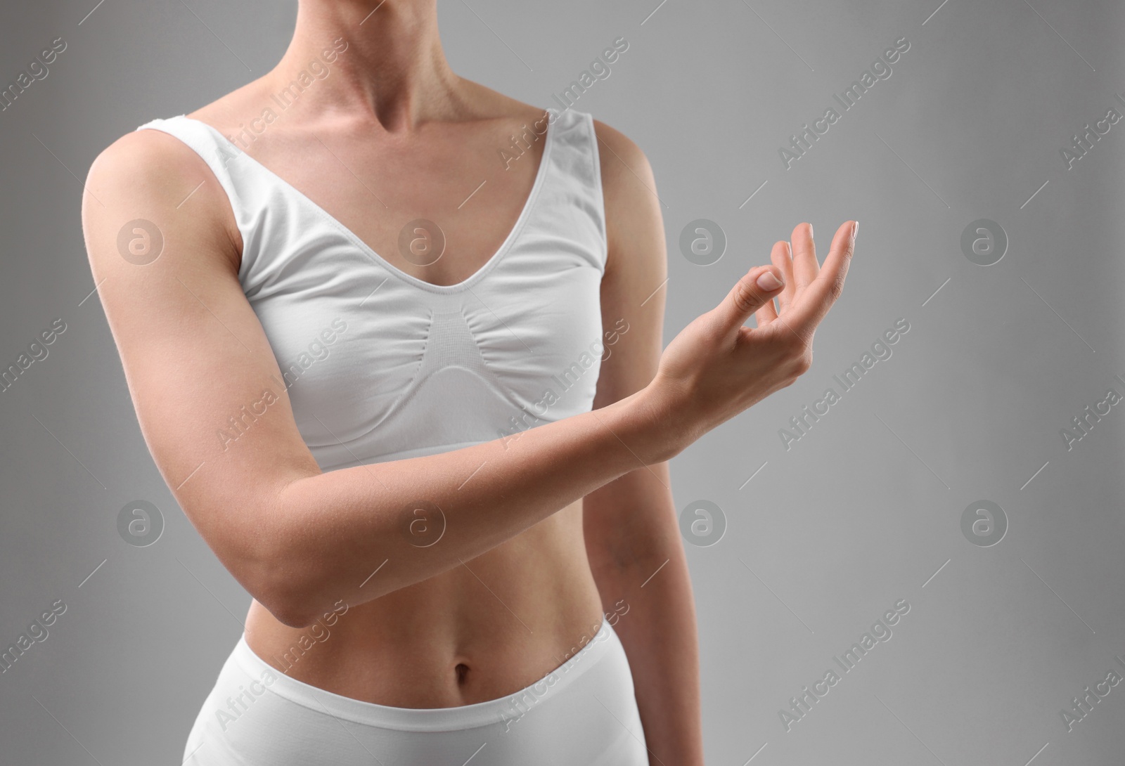 Photo of Sporty woman on grey background, closeup view