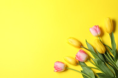 Photo of Beautiful colorful tulip flowers on yellow background, flat lay. Space for text