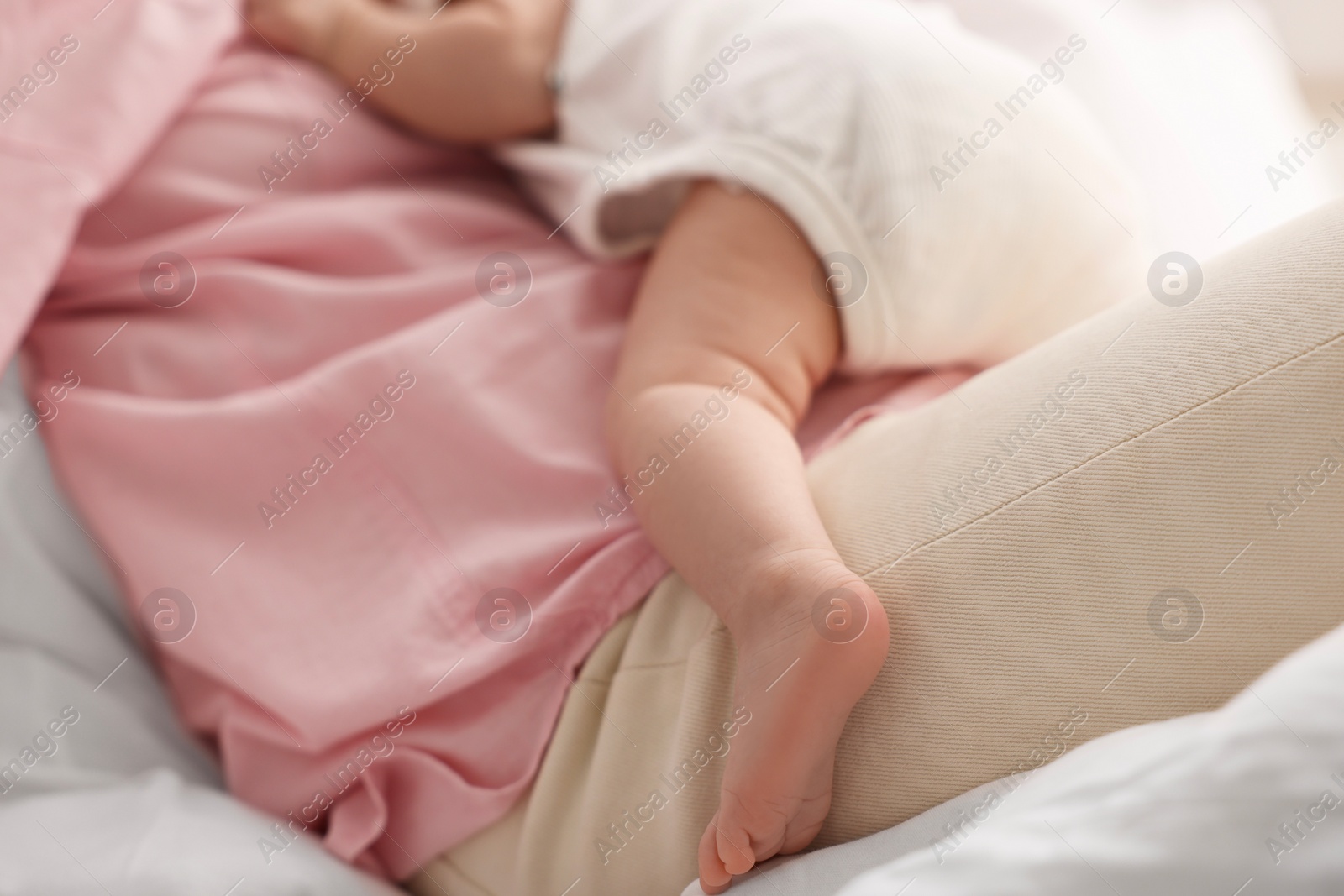 Photo of Mother with her sleeping newborn baby on bed, closeup