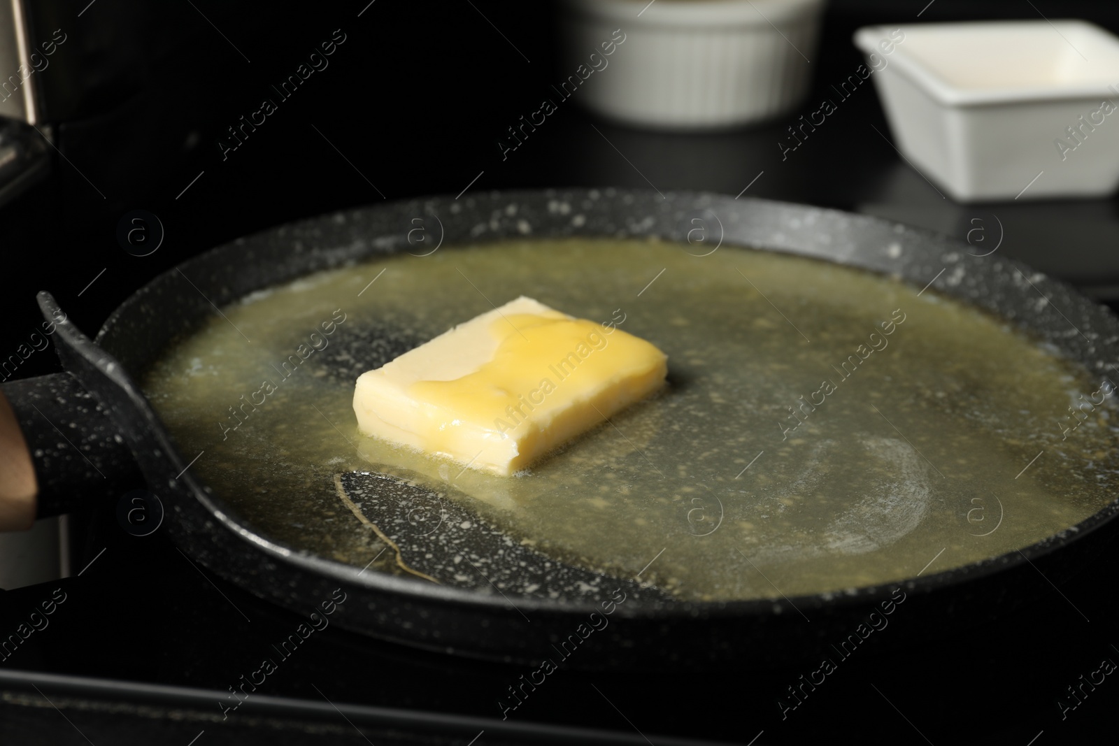 Photo of Melting butter in frying pan on black table, closeup