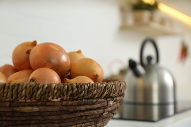 Photo of Basket with fresh onions in modern kitchen, closeup. Space for text
