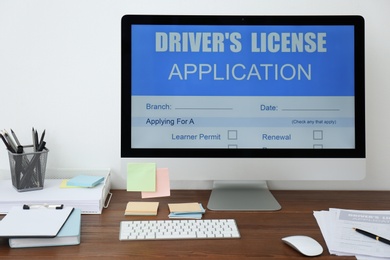 Photo of Computer with driver's license application form on table in office