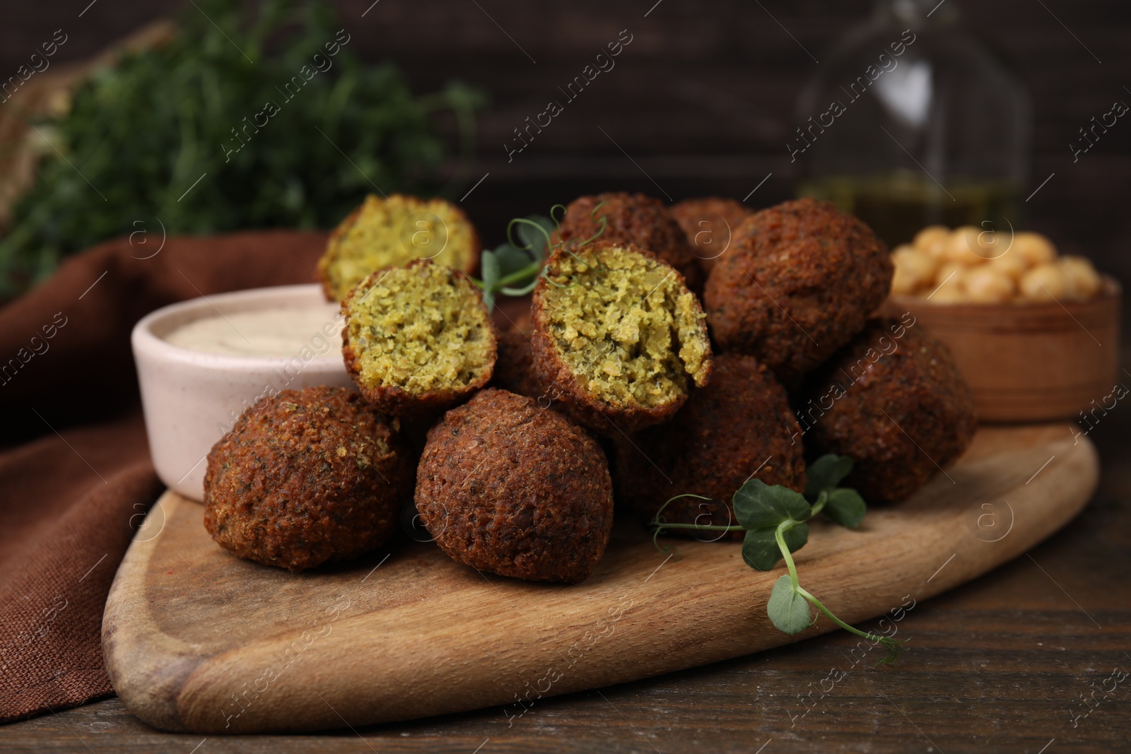 Photo of Delicious falafel balls and sauce on wooden table