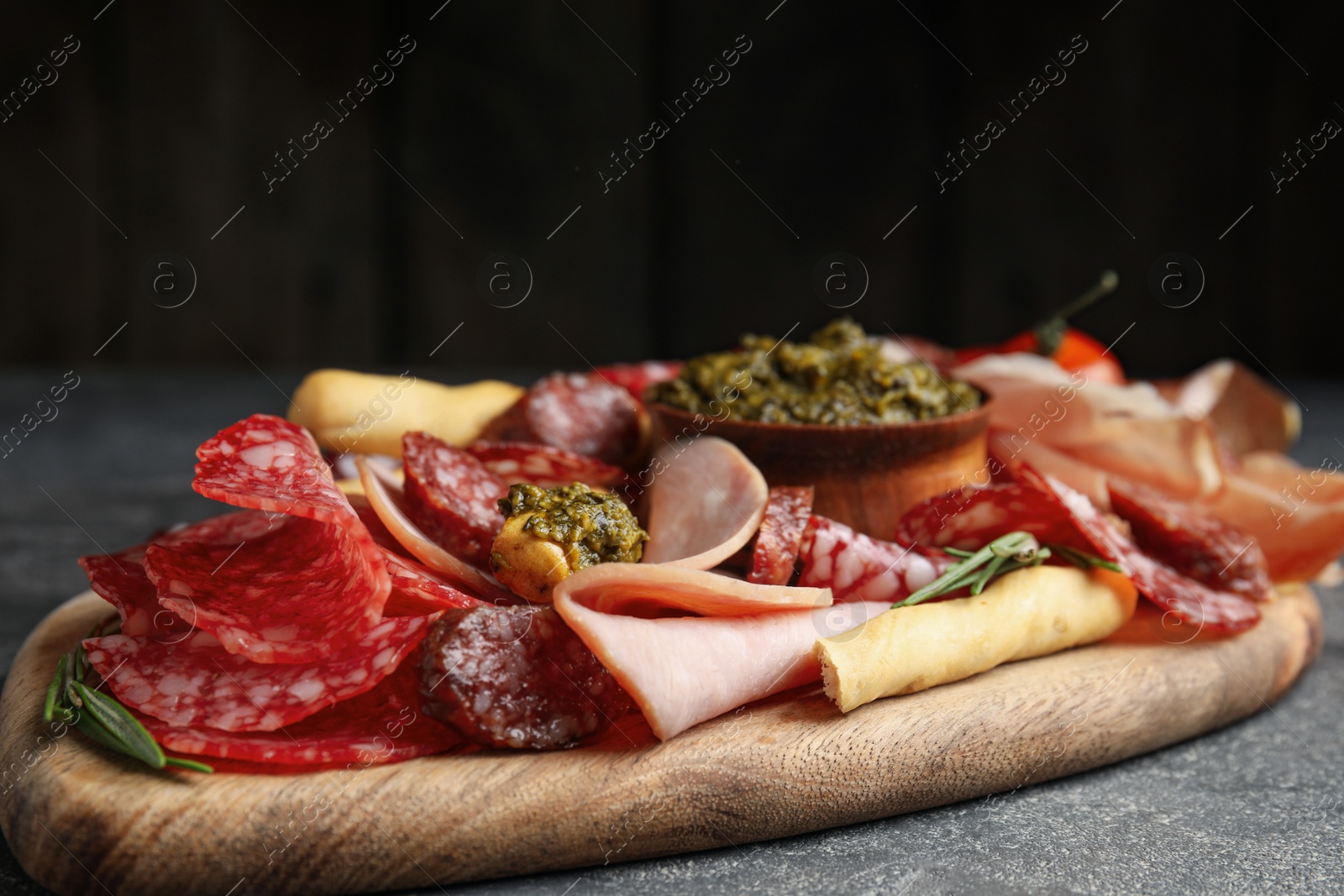 Photo of Tasty ham and other delicacies served on grey table, closeup