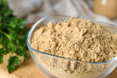 Photo of Bowl of aromatic mustard powder on table, closeup