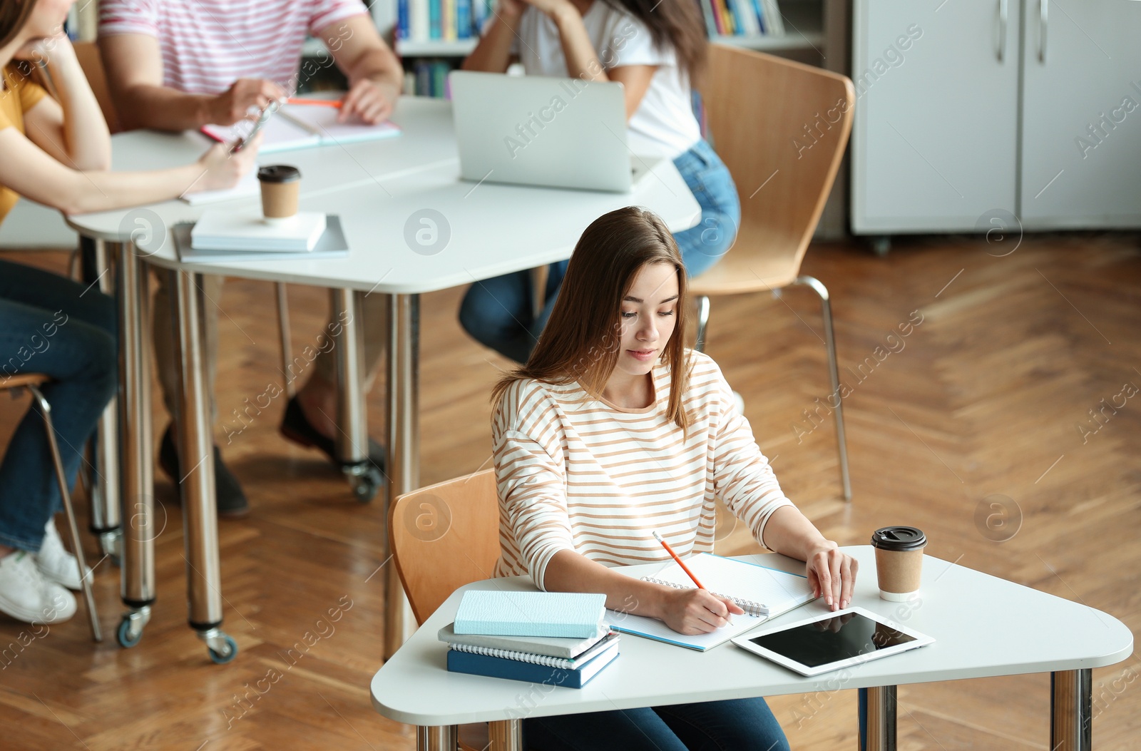 Photo of Young people studying at tables in library