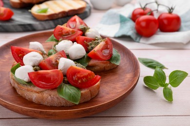 Photo of Delicious Caprese sandwiches with mozzarella, tomatoes, basil and pesto sauce on white wooden table, closeup