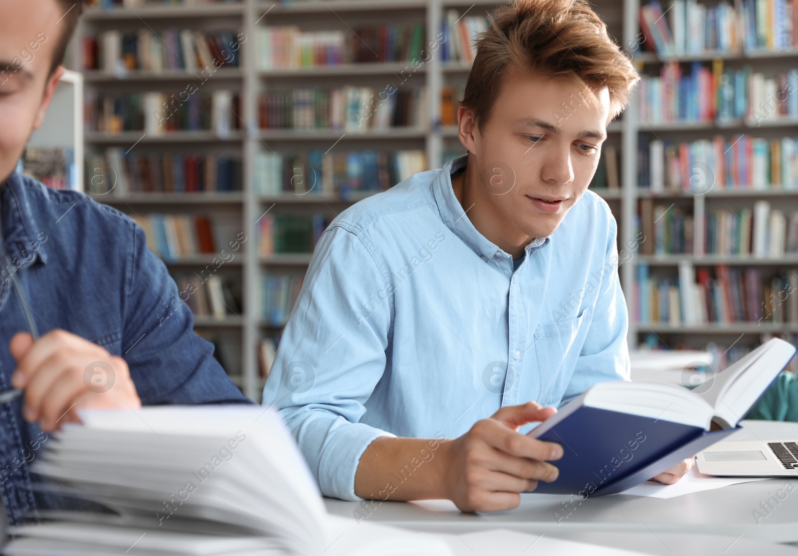 Photo of Young people studying at table in library