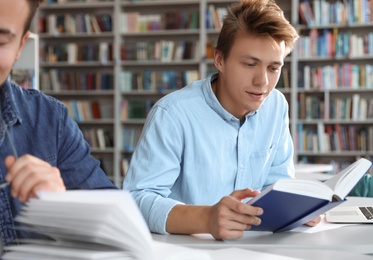 Photo of Young people studying at table in library