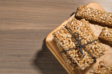 Photo of Delicious sweet kozinaki bars on wooden table, top view. Space for text