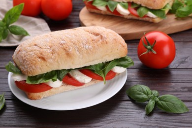 Delicious Caprese sandwich with mozzarella, tomatoes and basil on wooden table