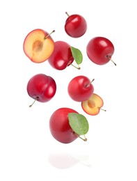 Delicious ripe cherry plums with leaves falling isolated on white