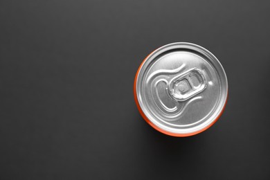 Photo of Energy drink in can on black background, top view. Space for text