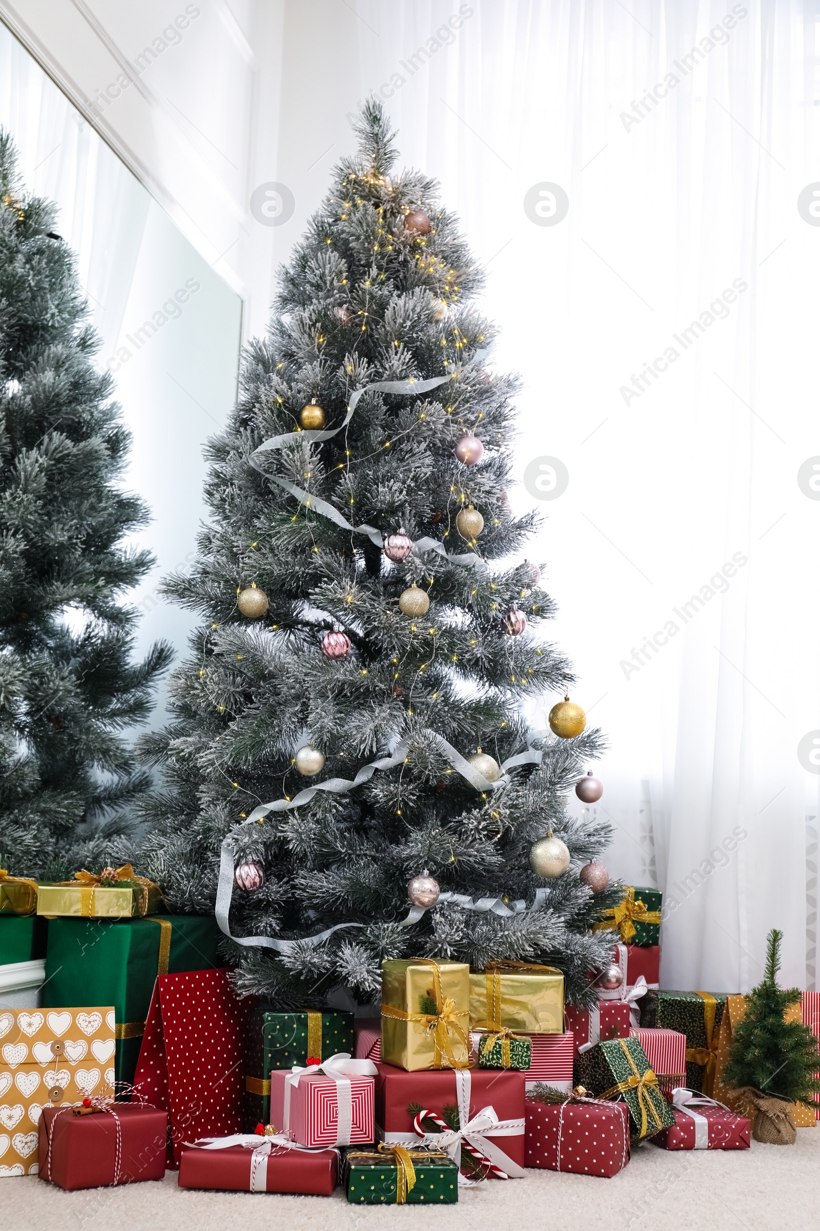 Photo of Many different gifts under Christmas tree indoors