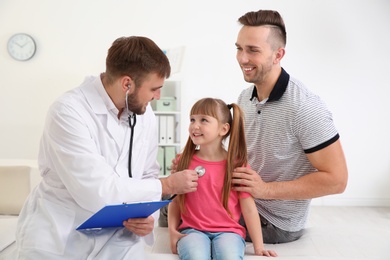 Children's doctor examining patient with stethoscope in hospital