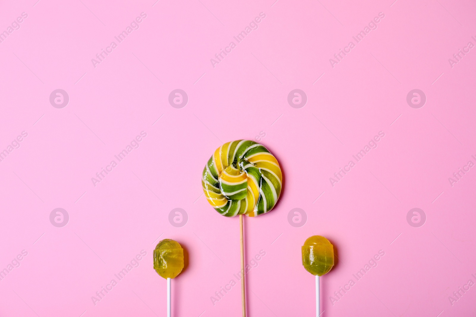 Photo of Bright yummy candies on color background, top view