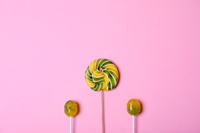 Photo of Bright yummy candies on color background, top view