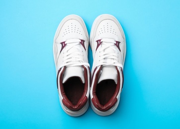 Photo of Pair of stylish shoes on blue background, top view