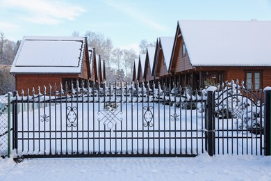 Houses and trees behind fence in winter morning