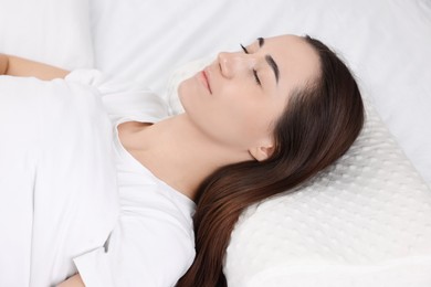 Woman sleeping on orthopedic pillow in bed