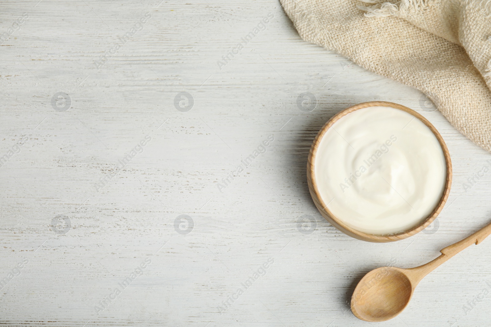 Photo of Tasty organic yogurt on white wooden table, flat lay. Space for text