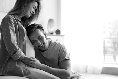 Photo of Young pregnant woman with husband at home, black and white effect