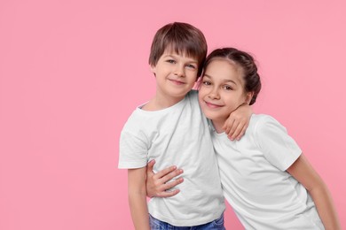 Photo of Happy brother and sister on pink background, space for text