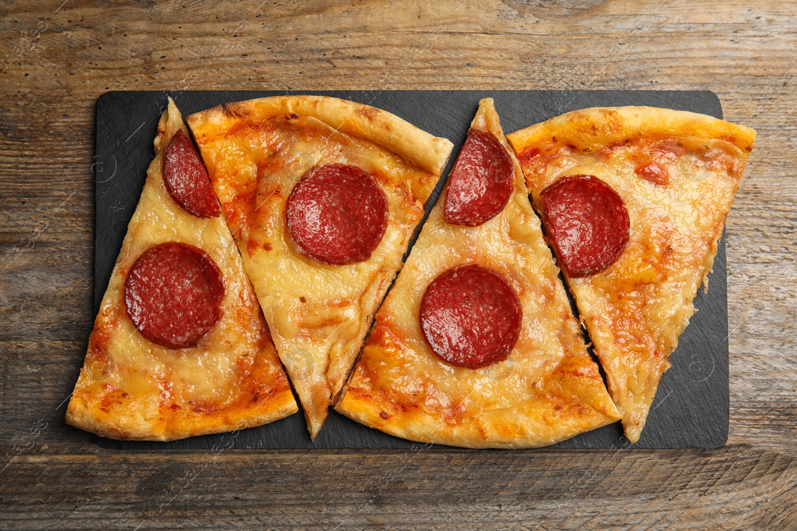 Photo of Tasty pepperoni pizza on wooden table, top view