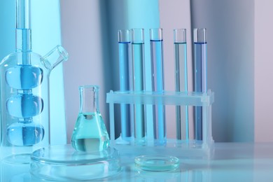 Laboratory analysis. Different glassware on table against color background