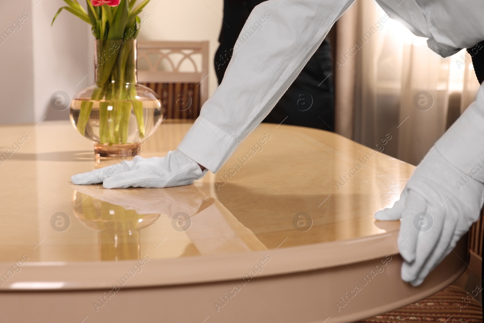 Photo of Woman near table in restaurant, closeup. Professional butler courses