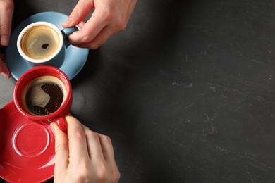 Photo of Women having coffee break at dark textured table, above view. Space for text