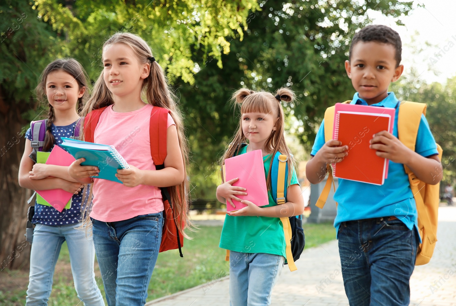 Photo of Cute little children with backpacks going to school