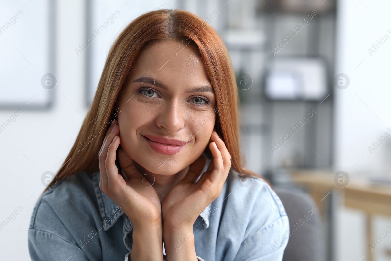 Photo of Portrait of beautiful young woman with red hair indoors. Attractive happy lady looking into camera. Space for text