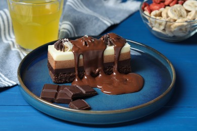 Photo of Tasty chocolate mousse cake on blue wooden table