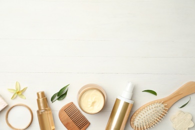 Photo of Flat lay composition with hair care cosmetic products on white wooden table. Space for text