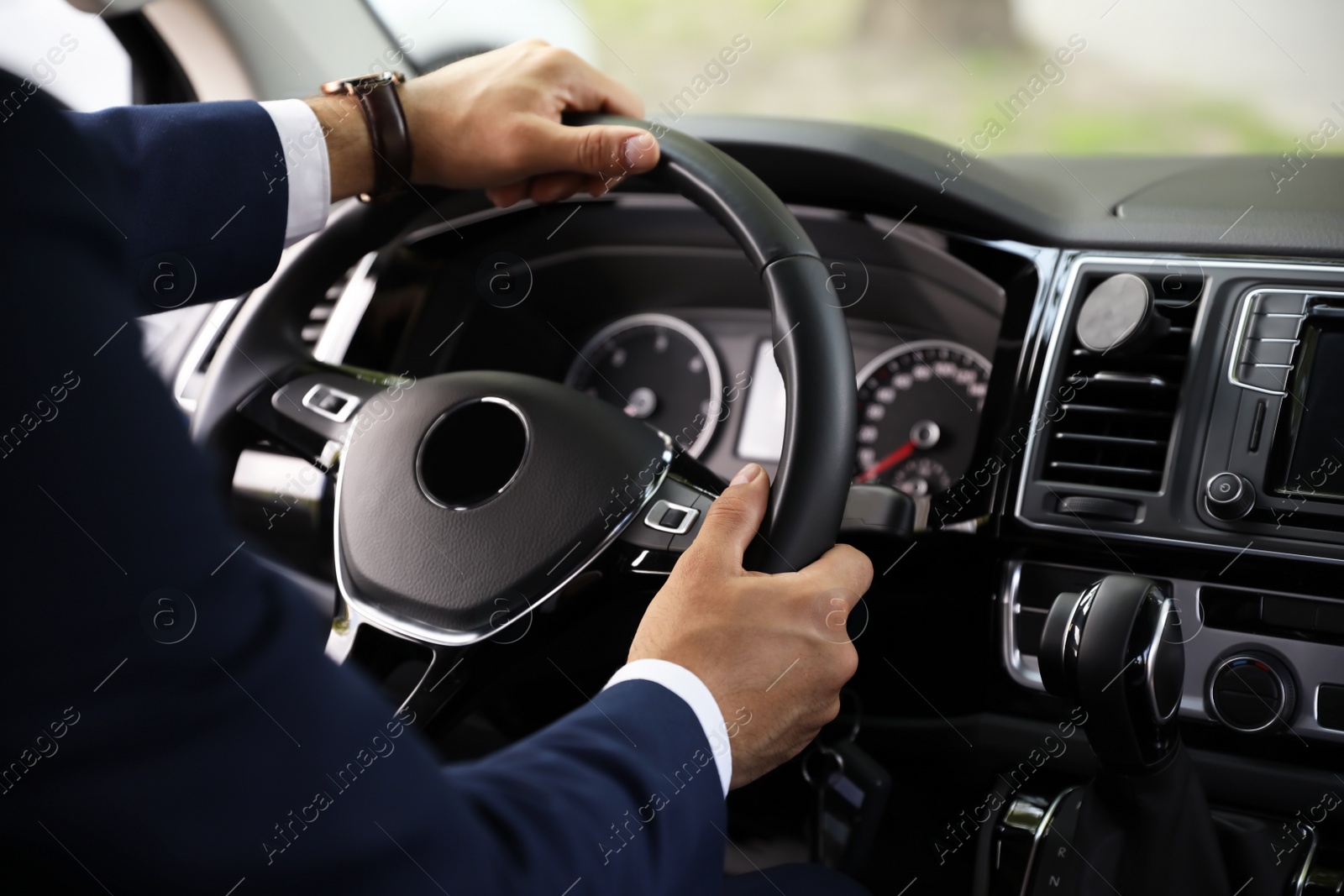 Photo of Man driving his car, closeup view of hands on steering wheel