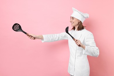 Professional chef with skimmer and ladle having fun on pink background