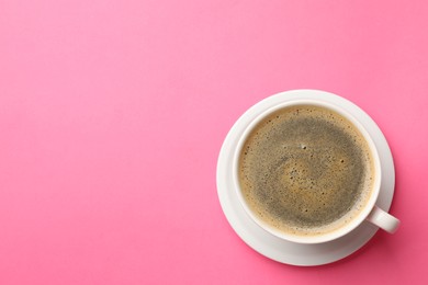 Photo of Fresh coffee in cup on pink background, top view. Space for text