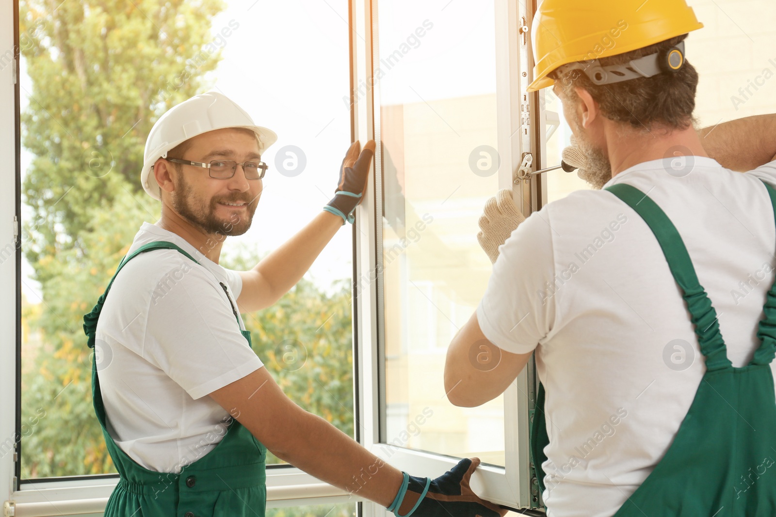 Photo of Construction workers installing new window in house