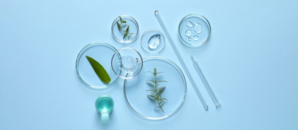 Image of Spa treatment. Flat lay composition with laboratory glassware and ingredients for organic cosmetic product on light blue background. Banner design