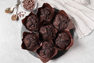 Photo of Tasty chocolate muffins on light table, flat lay