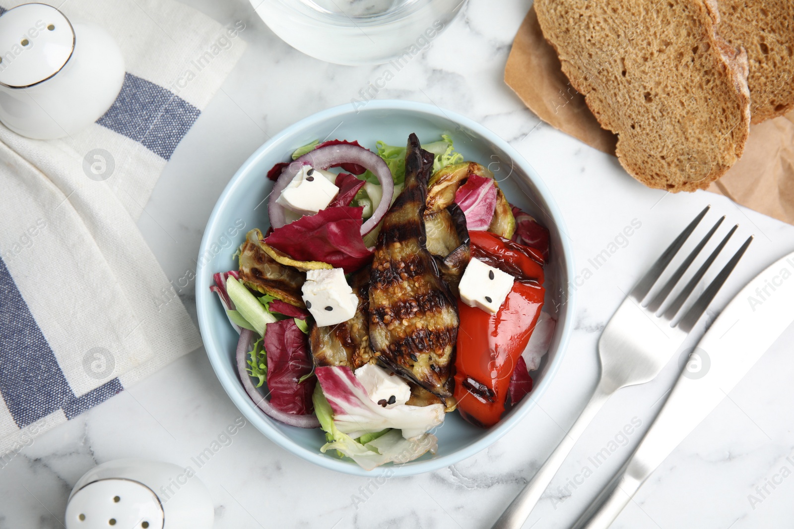 Photo of Delicious salad with roasted eggplant, feta cheese and chia seeds served on white marble table, flat lay