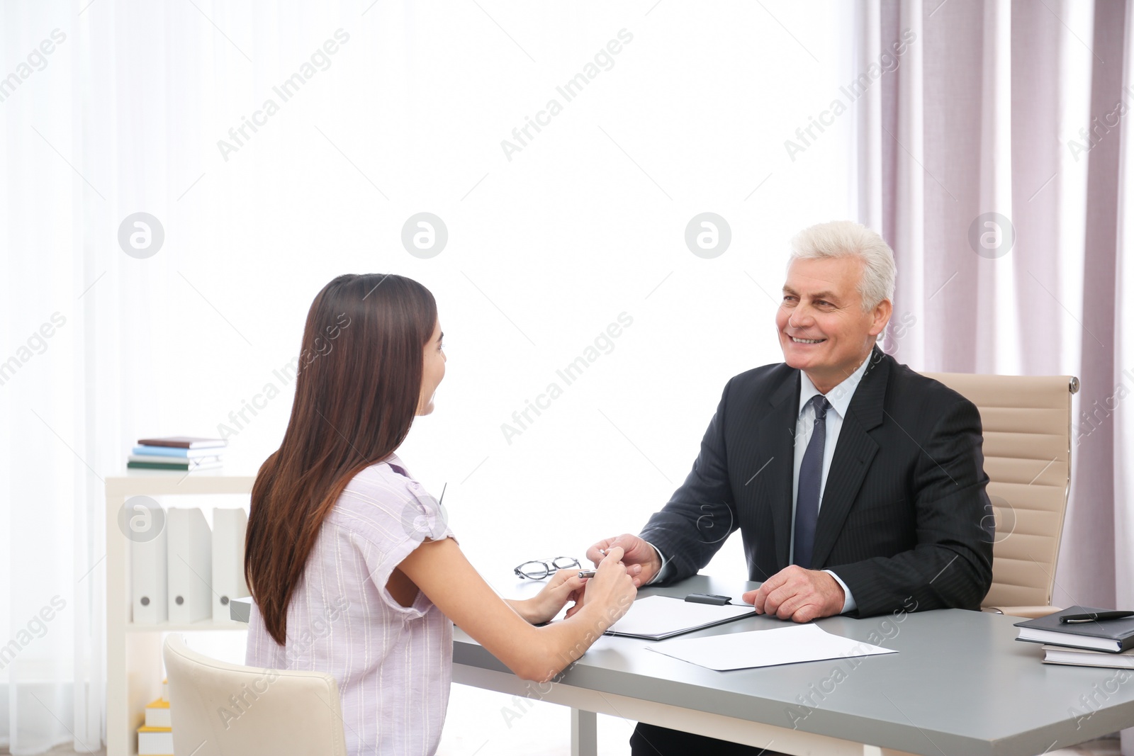 Photo of Young woman having meeting with lawyer in office